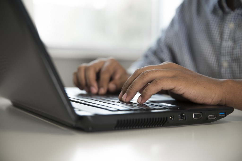 student typing on keyboard