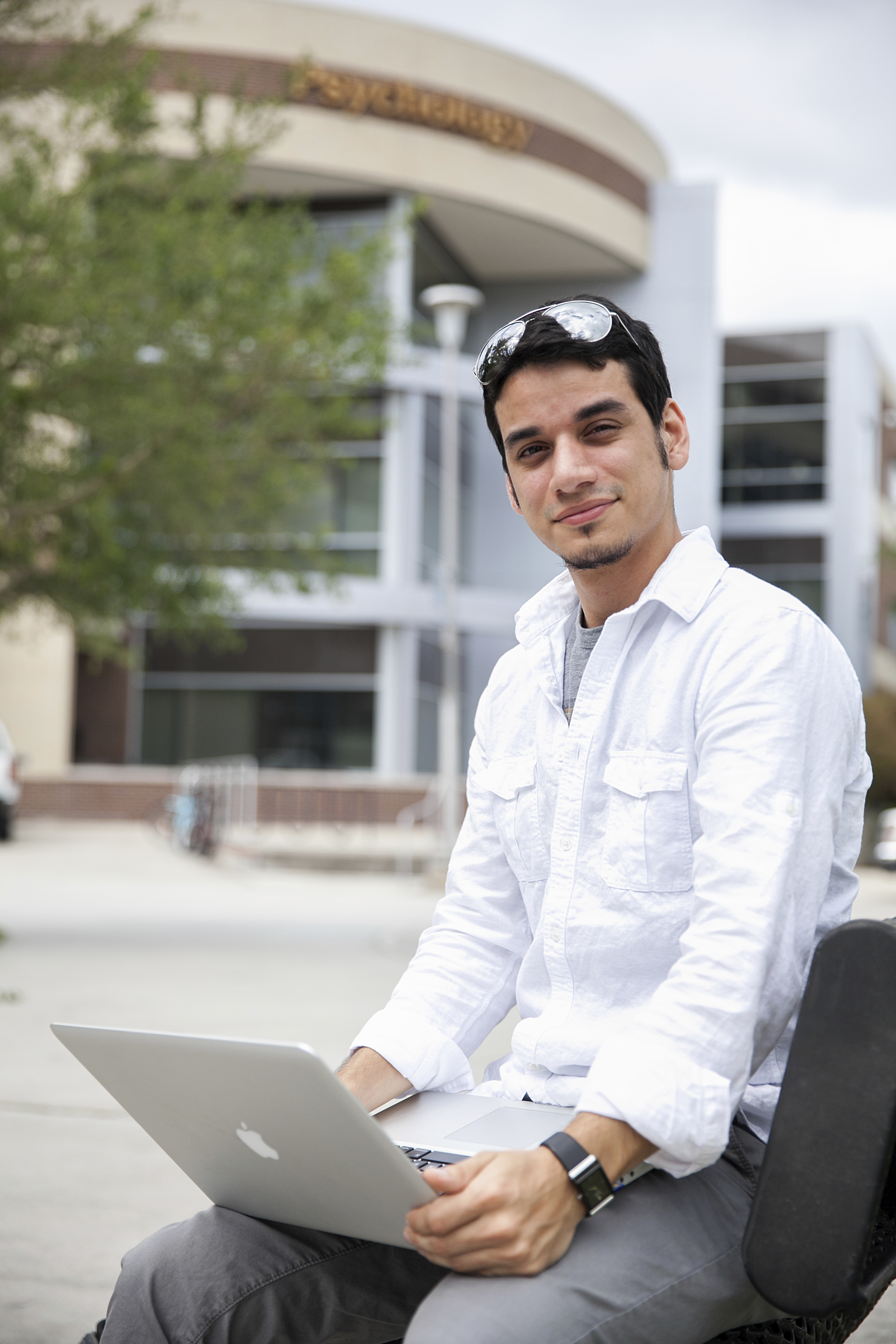 Student with laptop sitting outdoors