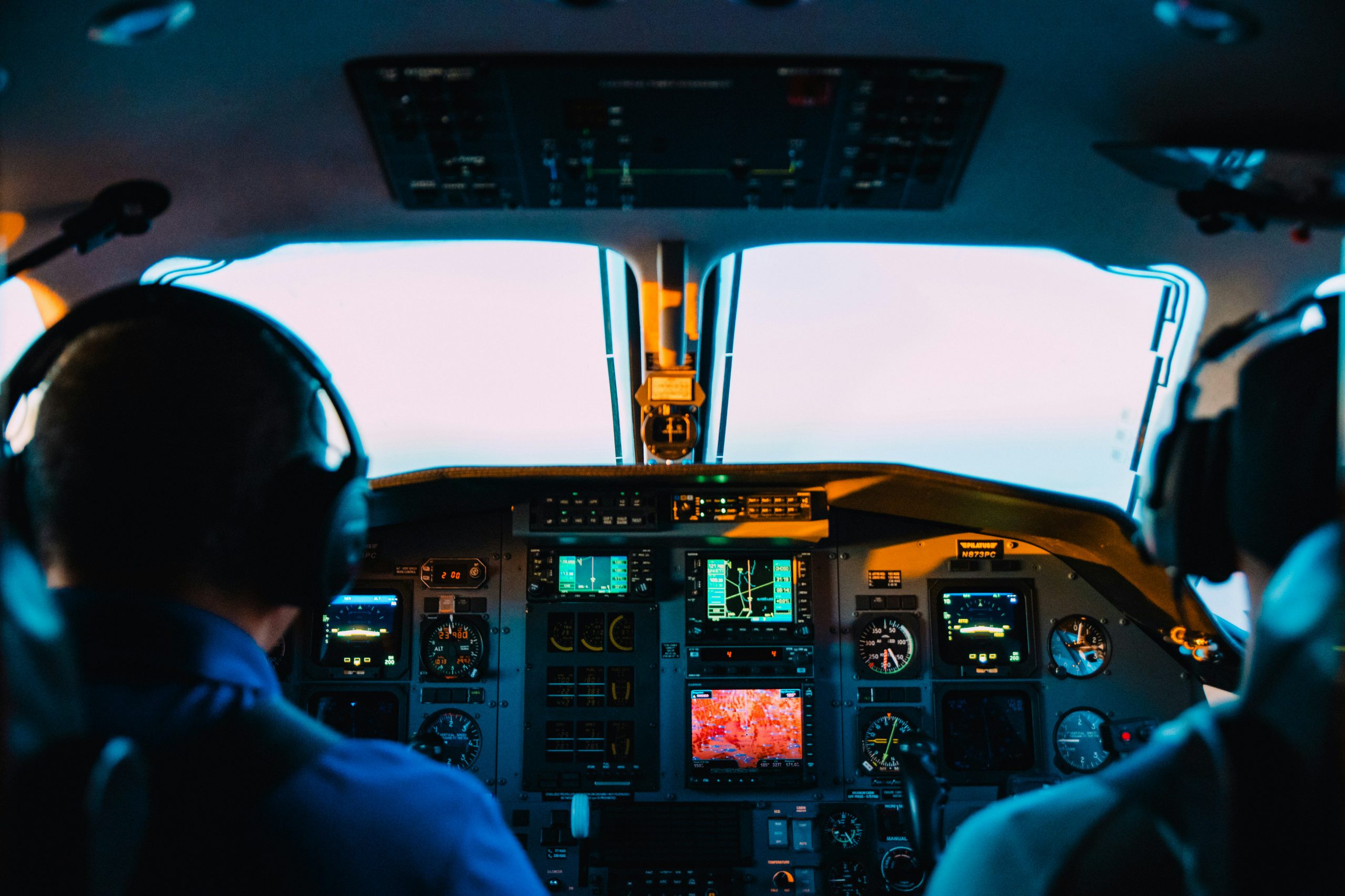 Two pilots sitting in the cockpit of a plane.