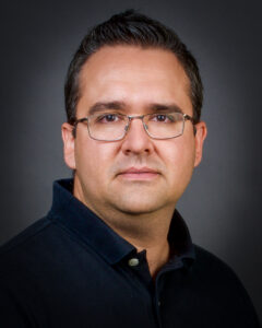 Headshot of Efrén de la Mora Velasco against dark background